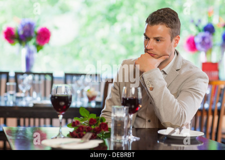 Uomo bello in attesa per la sua ragazza al ristorante Foto Stock