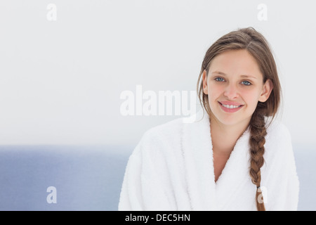 Donna sorridente in accappatoio Foto Stock