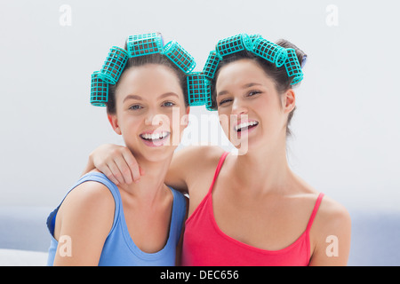 Le ragazze nei capelli rulli e pigiami sorridente in telecamera Foto Stock