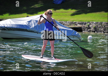 Una giovane donna su un stand-up paddleboard Foto Stock