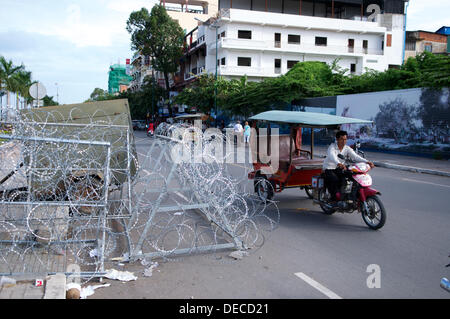 Phnom Penh Cambogia sul Sett. 16th, 2013. La polizia impostare il filo di rasoio barricate in tutta la città di Phnom Penh, Cambogia, nel timore di proteste politiche diventando violenta. un tuk-tuk o remork, il trasporto locale, passa in modo sicuro. Credito: Kraig Lieb / Alamy Live News Foto Stock