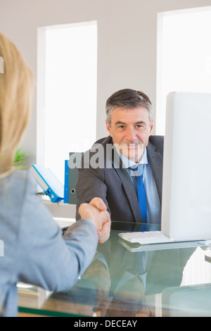 Imprenditore contenuto agitando la mano di intervistato Foto Stock