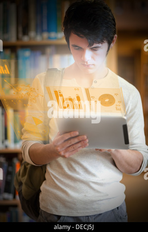 Serio studente bello lavorare al suo avveniristico tablet Foto Stock