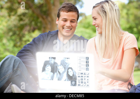Sorridente coppia giovane guardando le foto insieme su interfaccia digitale Foto Stock