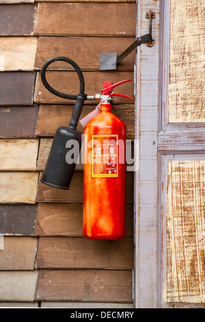 Vecchio estintore su parete in legno. Foto Stock