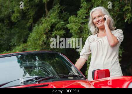 Sorridente donna matura avente chiamata telefonica Foto Stock