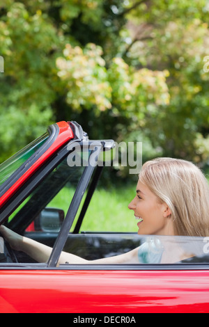 Donna felice guida cabriolet rosso Foto Stock