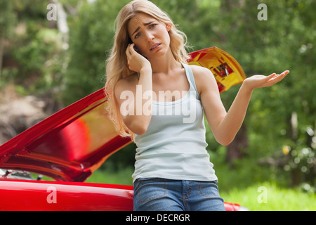 Bionda disperata che chiamano per richiedere assistenza dopo la rottura verso il basso Foto Stock