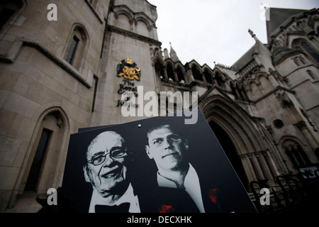 I manifestanti che indossano maschere di James Murdoch (L) e suo padre Rupert (R) dimostrano al di fuori dell'inchiesta Leveson Foto Stock