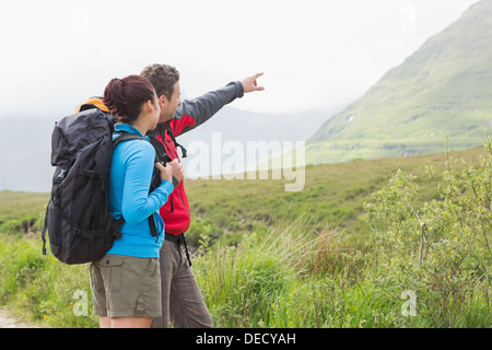 Paio di escursionisti con zaini rivolti a montagna Foto Stock