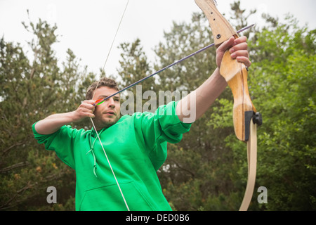 Concentrando l uomo praticare il tiro con l'arco Foto Stock