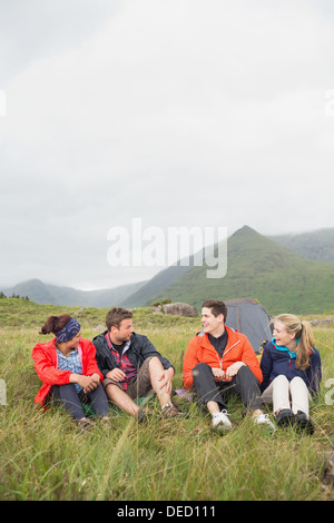 Gli amici di parlare insieme su un viaggio di campeggio Foto Stock