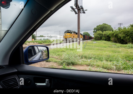 Dall'interno di un automobile, un avvicinamento treno merci è visibile attraverso la finestra. Foto Stock