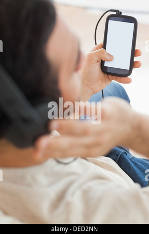 Close up sul giovane uomo con il suo smartphone per ascoltare la musica Foto Stock