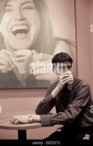 Uomo di bere il caffè nella caffetteria Foto Stock