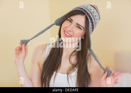 Funny Pretty girl cercando su un cappello di lana Foto Stock