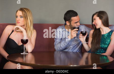 Donna bionda sensazione da soli come due persone sono flirtare accanto a lei Foto Stock