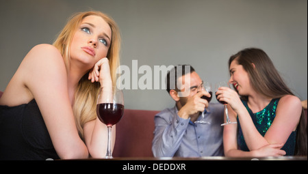 Donna bionda sentimenti di gelosia di due persone di flirting accanto a lei Foto Stock