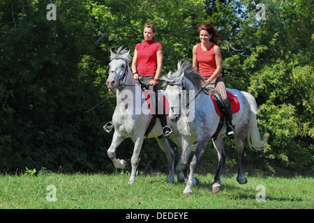 Due ragazze durante un giro fuori sul retro della coppia cavalli andalusi Foto Stock