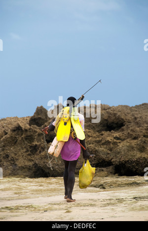 Un pescatore solitario con fucile teste fuori su un viaggio di pesca, Mozambico Foto Stock