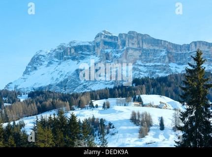 Bella inverno montagna rocciosa del paesaggio e case sul pendio. Italia Dolomiti, ai piedi del Passo Gardena, Alto Adige. Foto Stock