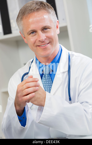 Sorridenti maschio medico nel suo ufficio dell'ospedale Foto Stock
