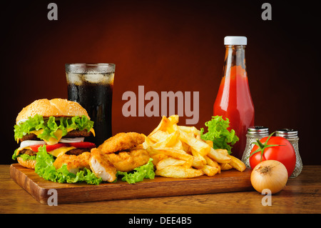 Il fast food menu con hamburger o cheeseburger, tradizionale patatine fritte, pepite di pollo, cola e tomato ketchup Foto Stock