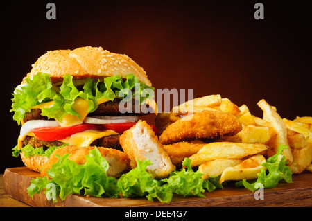 Ancora vita con tradizionale cheeseburger fritto di pepite di pollo e patatine fritte Foto Stock