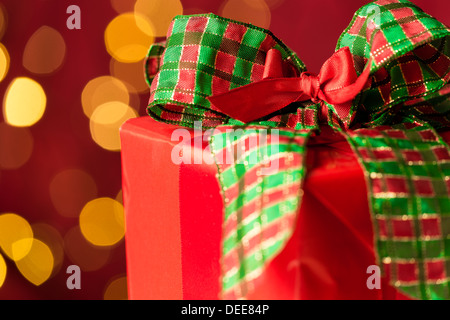 Regalo di natale e scintillanti luci sfocati sullo sfondo di colore rosso e verde Foto Stock