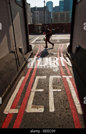 Girare a sinistra oltre il doppio di linee rosse della segnaletica stradale nella città di Londra Foto Stock