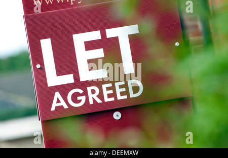 Agente immobiliare lasciare segno convenuto al di fuori di immobili residenziali Foto Stock