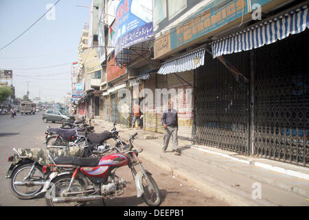 Negozi visto chiuso dopo che il target di uccisione dei due lavoratori politico nella zona Golimar di Karachi il Martedì, 17 settembre 2013. Foto Stock