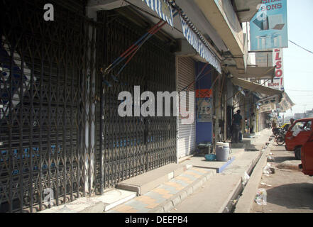 Negozi visto chiuso dopo che il target di uccisione dei due lavoratori politico nella zona Golimar di Karachi il Martedì, 17 settembre 2013. Foto Stock