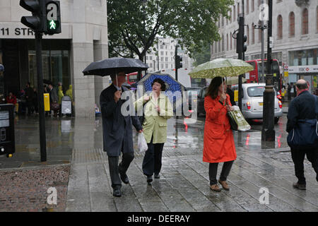 Londra, Regno Unito. Xvii Settembre 2013. Persone corsa con ombrelloni di uscire dalla pioggia pesante in London Credit: ©Keith Larby/Alamy Live News Foto Stock