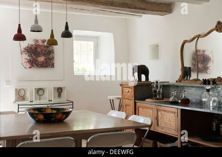 Basso soffitto di travi con zinco-sormontato bancone bar e legno sbiancato tavolo quadrato con 60's sedie cromate Foto Stock