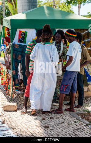 Africa, Angola, Benguela. Rastafarian uomini riuniti fuori strada shop. Foto Stock