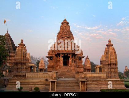 Tempio indù, costruito da Chandela Rajputs, presso la Western sito in India di Khajuraho durante il sunrise. Foto Stock