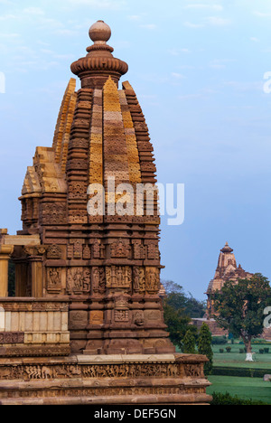 Plafoniera laterale del tempio indù, costruito da Chandela Rajputs, presso la Western sito in India di Khajuraho isolata contro la mattina presto del cielo Foto Stock