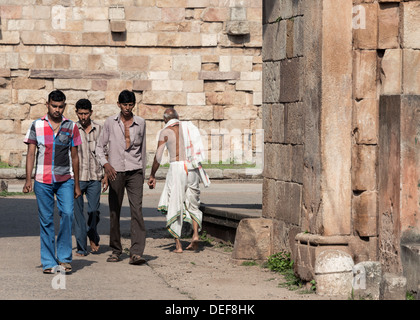 Indian uomini indossando il tradizionale e il moderno abito passando attraverso l'East Gate Bhadra, Champaner, India Foto Stock