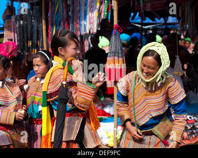 Felice fiore donne Hmong ridere e shop presso la domenica mattina il mercato di Bac Ha, Vietnam. Foto Stock