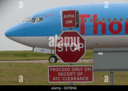 Aereo di linea di rullaggio dietro il veicolo 'stop' firmare all'aeroporto di Luton Foto Stock