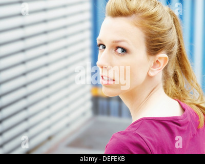 Donna che guarda sulla sua spalla Foto Stock