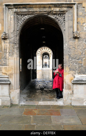 Una donna si erge contro una parete, la lettura di un libro. Università di Oxford, Regno Unito Foto Stock