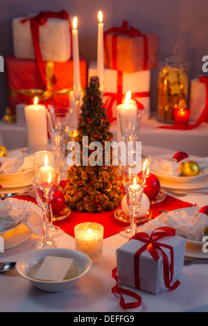 Lume di candela, fetta e regali di Natale sulla tabella