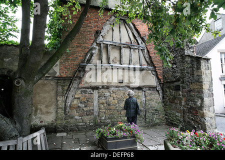 Un di legno cruck rimanente dalla demolizione di un vecchio edificio medievale, High Street, Wirksworth, Derbyshire. Foto Stock