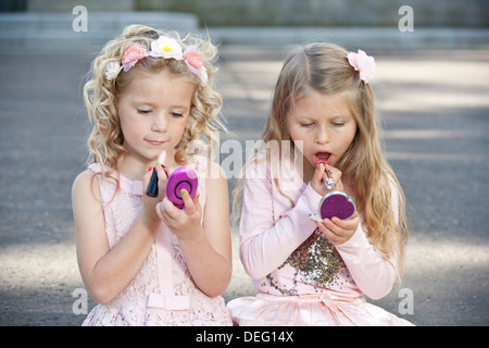 Due giovani ragazze preteen indossando rosa e putting fanno fino a. Foto Stock