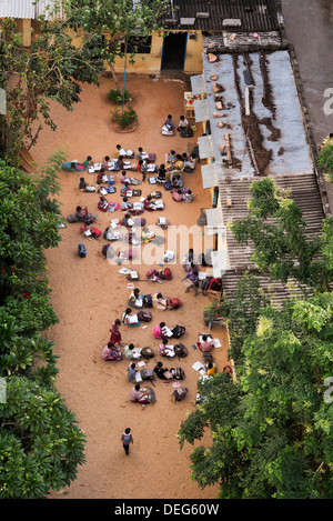 Indian inglese scuola media con i bambini a fare le lezioni in seduta il cantiere di sabbia. Puttaparthi, Andhra Pradesh, India Foto Stock