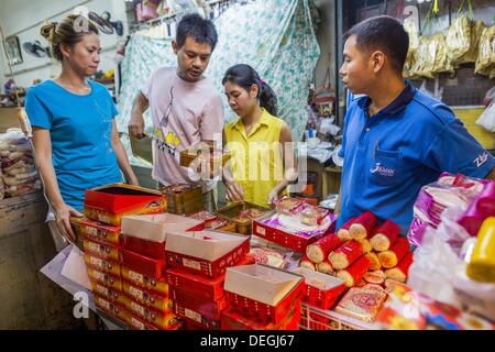 Sett. 18, 2013 - Bangkok, Thailandia - la gente compra mooncakes in un mercato nella sezione di Chinatown di Bangkok. Thailandia in generale e di Bangkok in particolare ha una vivace tradizione di cibo di strada e mangiare sull'esecuzione. In questi ultimi anni, Bangkok street food è diventata qualcosa di un punto di riferimento internazionale e viene scritto su carta lucida in riviste di viaggio e nelle pagine del New York Times. Mooncake cinese è un prodotto da forno tradizionalmente consumato durante il Mid-Autumn Festival (Zhongqiu). Il festival è per il culto lunare e guardare la luna, quando mooncakes sono considerati come un indispensabile Foto Stock