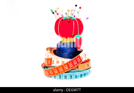 Tre le misure lineari a nastro avvolto intorno alla bobina di cotone con cuscino di pin Foto Stock