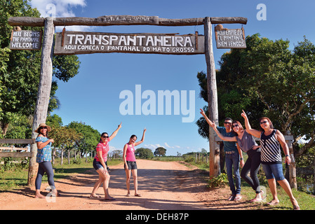Il Brasile, Pantanal: turisti brasiliani in posa per snap shot di fronte all'entrata principale della strada Transpantaneira Foto Stock